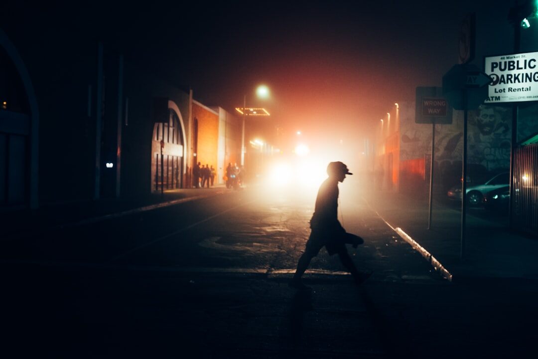 Illustrated noir book cover of a silhouette walking a foggy street at night