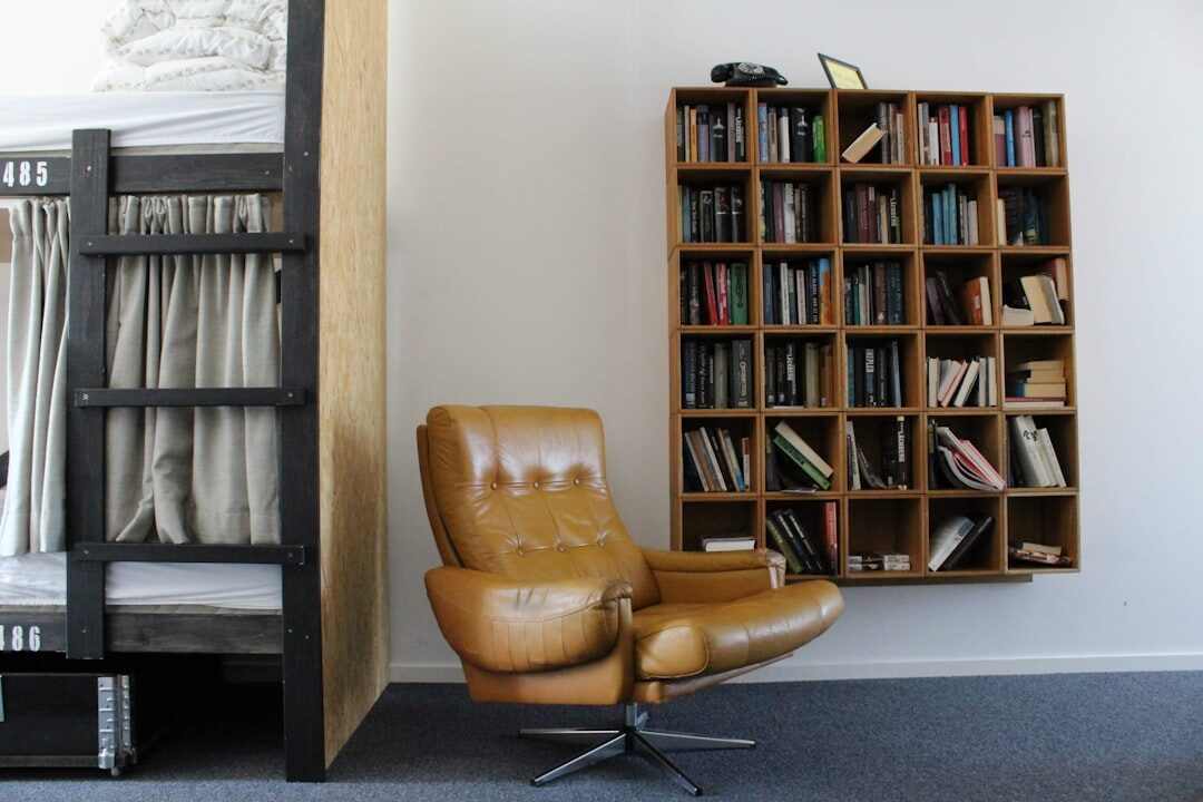 Cozy armchair reading nook surrounded by tall bookshelves