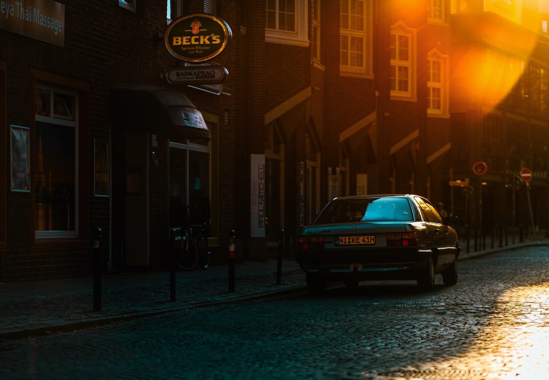 Illustrated detective novel cover with a vintage car outside a dim lit cafe